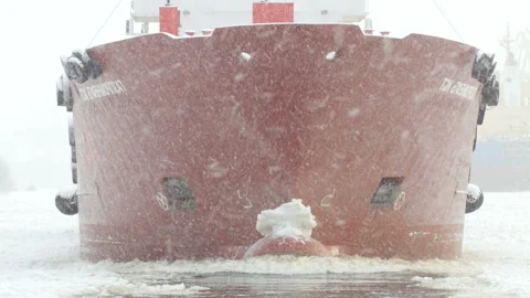 Nose of cargo ship moving in winter water, snow falling, oil tanker moves Stock-Footage 100031377