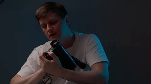 Nostalgic cameraman examining and operating old vintage video camcorder to Stock Footage 342812815