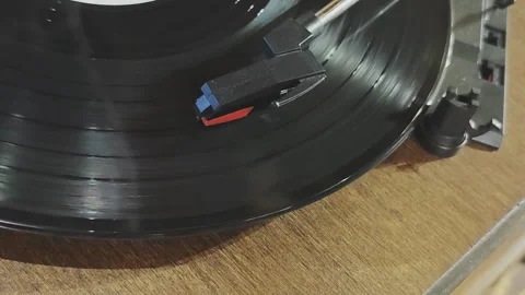 Nostalgic close up view of a spinning vinyl record. The player's stylus traces Video stock 343128252