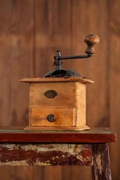 Nostalgic coffee grinder on old stool Stock Photos