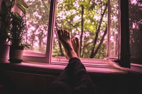 Nostalgic concept, opened window in cozy walm home while it rains outdoor Stock Photos