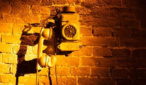 Nostalgic Echo: Old Telephone on a Rustic Brick Background Foto stock