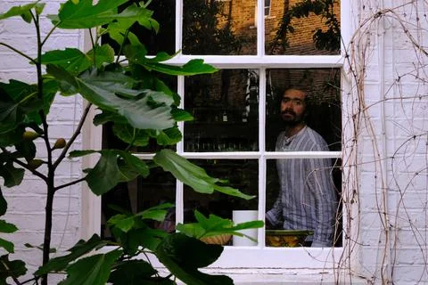 Nostalgic mid aged man looking through the window Stock Photos