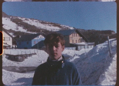 Nostalgic winter scene, young boy wearing blue jacket standing amid snowy Stock Footage 306659075