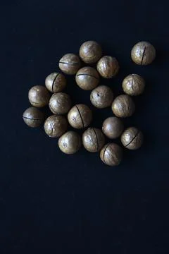 Not broken macadamia nuts on a black background in the group. Foto stock