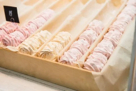 Not full rows of fruit pink and yellow marshmallow, zephyr desserts in wooden Foto stock