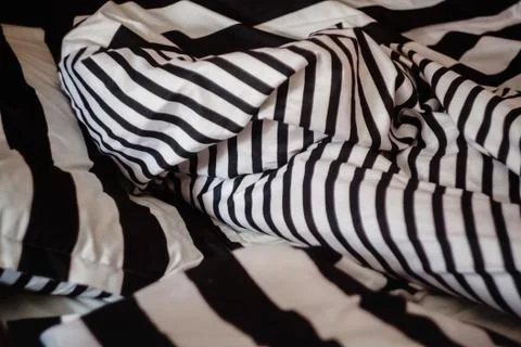 Not the laid bed with a pattern of black-and-white strip, close-up. Stock Photos