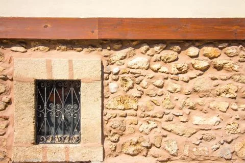 Not a large window with bars in the stone wall. Stock Photos