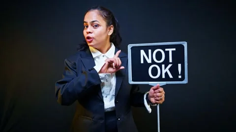 Not ok displayed boldly on protest placard held by woman Stock Footage 303129766