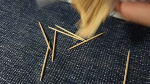 Not struggling to select one pointy wooden toothpick out of the case, just Stock-Footage 122353583