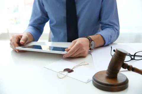 Notary working with tablet and judge gavel on table, closeup. Law and justice Stock Photos