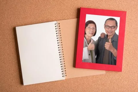 Note book and blank frame on wooden table Stock Photos