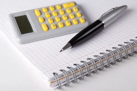 Note book with checked pages, pen and calculator Stock Photos