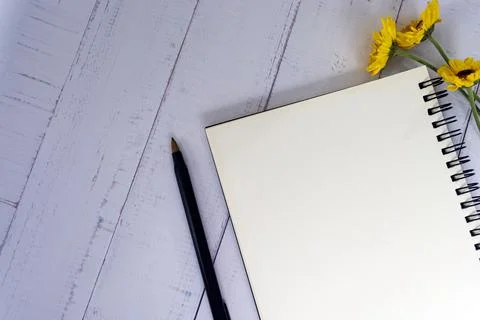 Note book flat lay with sunflowers on wooden desk. Directly above. Stock Photos