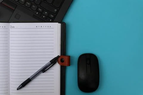 Note book, pen and laptop on blue table Stock Photos