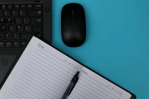 Note book, pen and laptop on blue table Stock Photos