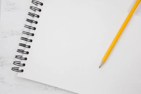 Note book on white table with yellow pencil Stock Photos