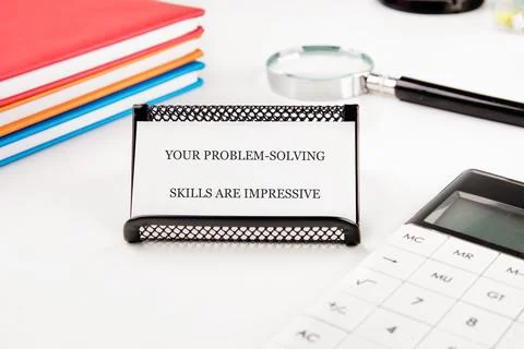 A note displays the message about impressive problem-solving skills, placed o Stock Photos