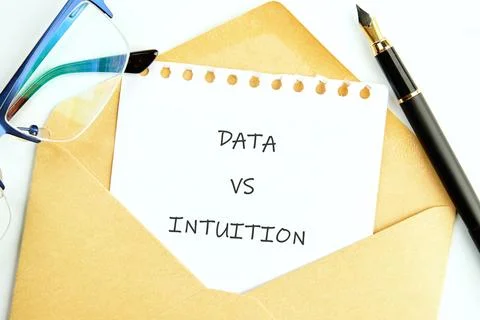 A note explaining the contrast between data and intuition lies inside an enve 스톡 사진