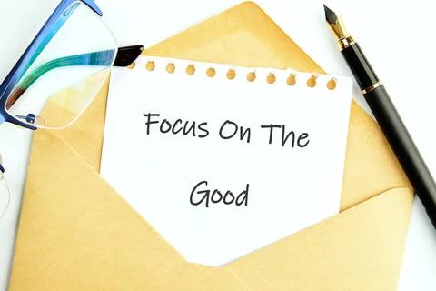 A note with Focus On The Good written on it rests in an envelope, accompanied by Stock Photos
