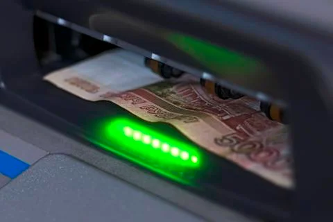 The note is inserted into the open ATM receiver Stock Photos