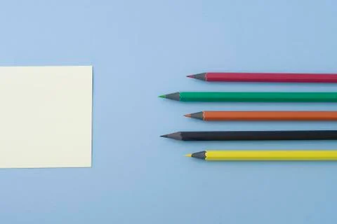 Note with multicolored pencils aligned at the center of the photo isolated on Stock Photos