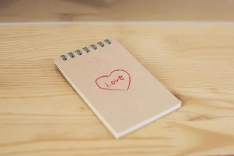 Note pad with heart shape and word love written on cover Stock Photos