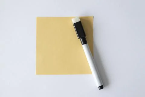 A note pad for writing on a white background next to the felt-tip pen. Stock Photos