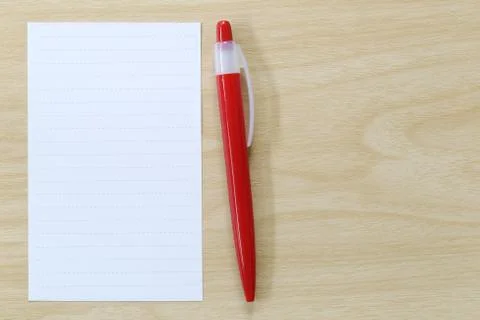 Note paper and red pen placed on wooden floor. Stock Photos