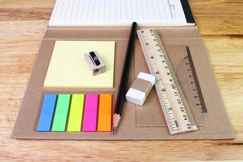Note paper colour and pencil eraser ruler with book on woodtable 库存照片