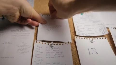 Note paper on a cork board. Notes, stickers, reminders. Selective focus. Men's h Stock Footage 147934529