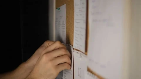 Note paper on a cork board. Notes, stickers, reminders. Selective focus. Men's h Stock Footage 149970961