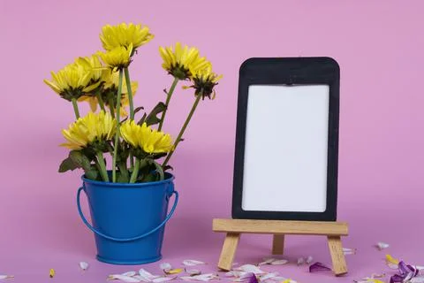 Note paper with frame and and flowers in blue bucket on pink background. Foto stock