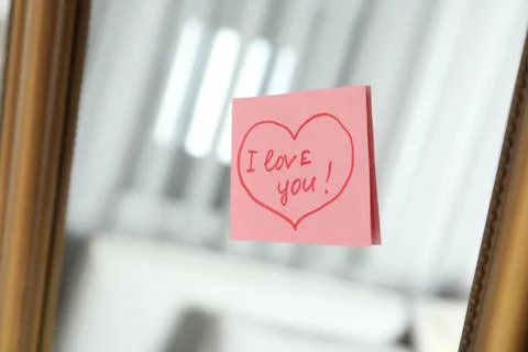 Note with phrase I Love You attached to mirror Stock Photos
