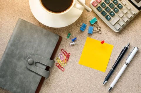Note placed on the table and a cup of coffee office supplies on the table. Stock Photos