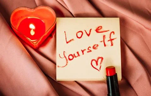 A note to self with a call to love yourself drawing with red lipstick pink silk Stock Photos