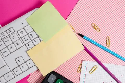 Note sheet sticked to computer keyboard near patterned fabric and stationary Foto stock