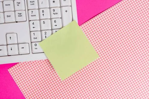 Note sheet sticked to computer keyboard near patterned fabric above a colo... Foto stock