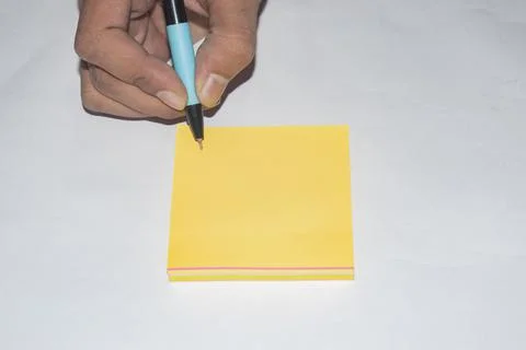 Note something in a yellow paper.White Background. Stock Photos