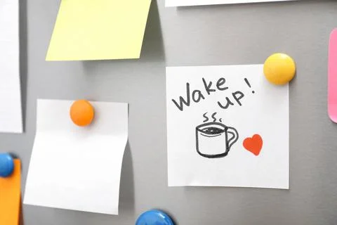 Note with text "Wake up" and empty sheets on refrigerator door. Space for tex Stock Photos