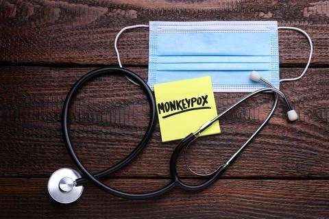 Note with word Monkeypox, mask and stethoscope on wooden table, flat lay Stock Photos