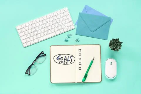 Notebook with 2026 goals, computer keyboard and envelopes on green background Stock Photos