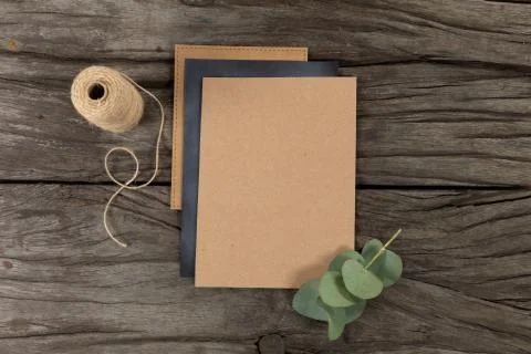 Notebook and black sheet of paper surrounded by a flower and knitting yarn on Stock Photos