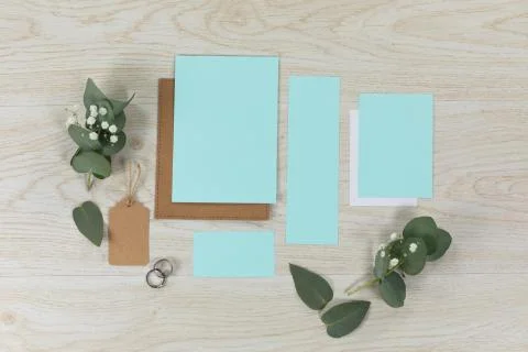 Notebook and blue sheet of papers surrounded by flowers on wood table Stock Photos