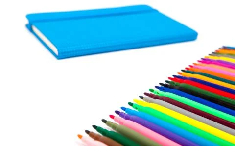 Notebook and multicolored markers on a white background Stock Photos
