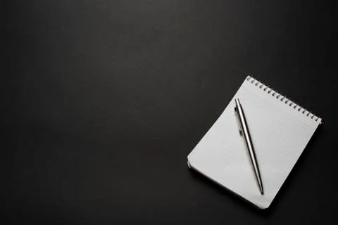 Notebook and pen on a black table Stock Photos