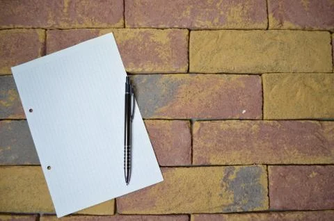 Notebook and pen on brick background Stock Photos