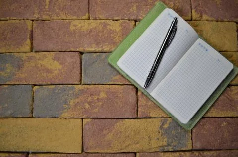 Notebook and pen on brick background Stock Photos