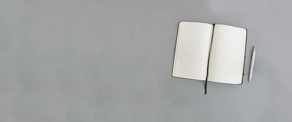 Notebook and pen on a gray background, copy space. Banner Stock Photos