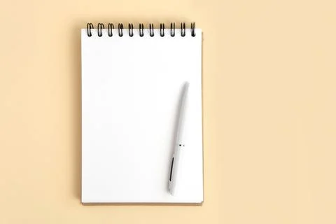 Notebook and pen. Spiral notepad on neutral beige color studio background. .. Photos